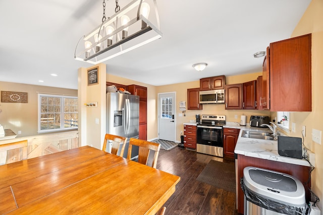 kitchen featuring dark wood-style flooring, stainless steel appliances, light countertops, and a sink