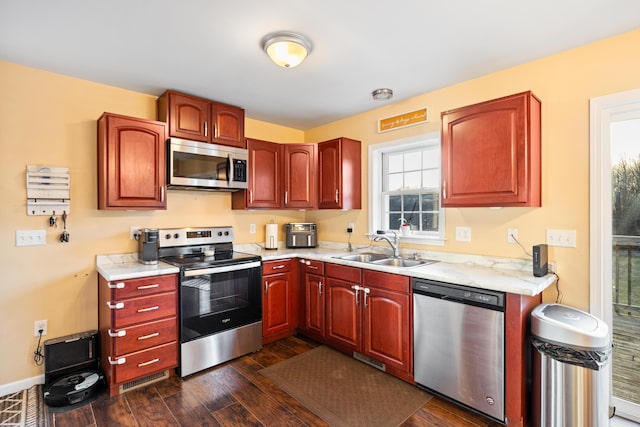 kitchen with a sink, light countertops, dark wood-style floors, and stainless steel appliances