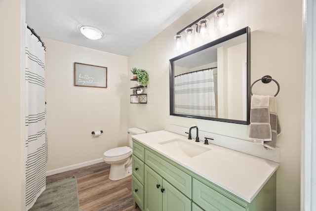 full bath featuring baseboards, toilet, wood finished floors, and vanity