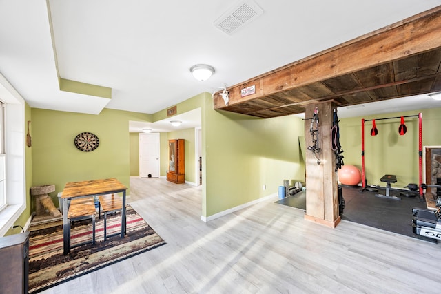 workout area featuring visible vents, baseboards, and wood finished floors