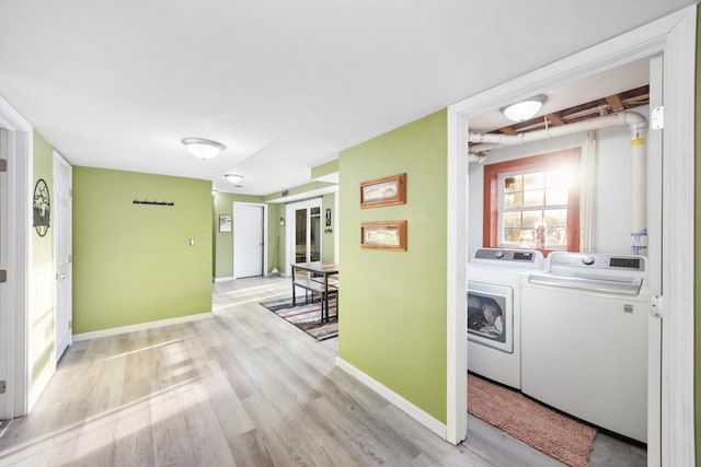 hall featuring baseboards, independent washer and dryer, and wood finished floors