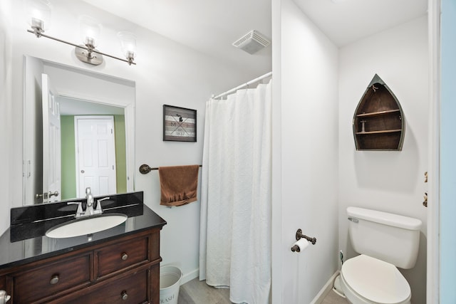 bathroom featuring visible vents, toilet, a shower with curtain, baseboards, and vanity