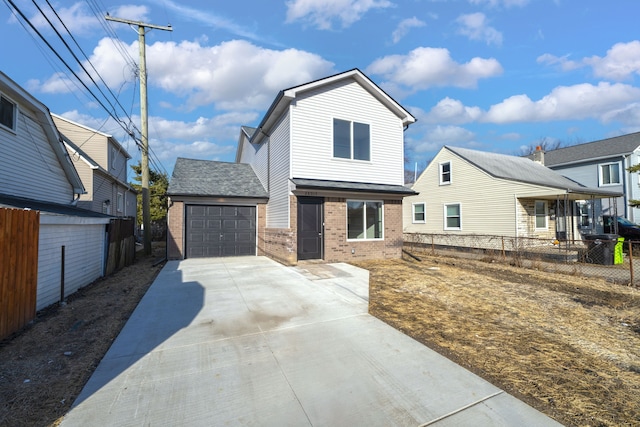 traditional-style house featuring concrete driveway, an attached garage, fence, and brick siding