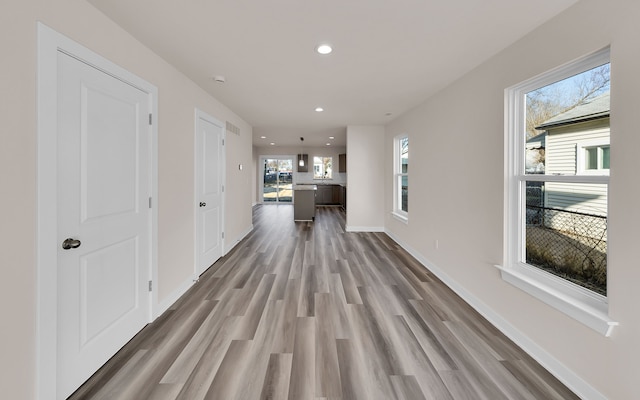 hallway with recessed lighting, wood finished floors, and baseboards