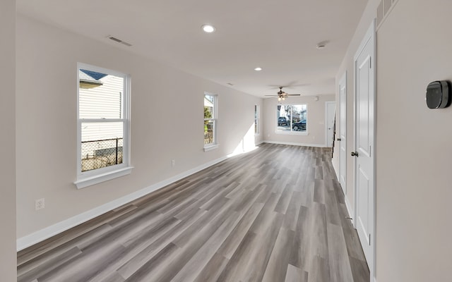 interior space featuring a ceiling fan, wood finished floors, visible vents, baseboards, and recessed lighting