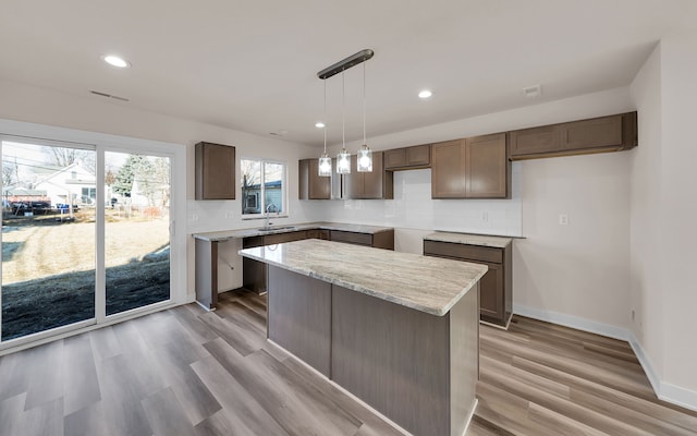 kitchen featuring light wood finished floors, recessed lighting, and backsplash