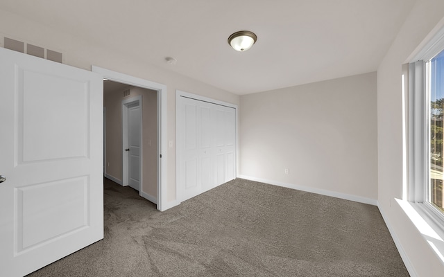 interior space with carpet, visible vents, a closet, and baseboards