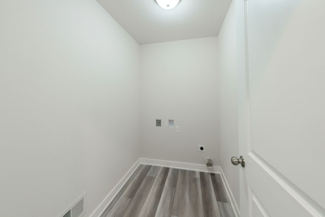 clothes washing area with baseboards, washer hookup, laundry area, wood finished floors, and hookup for an electric dryer