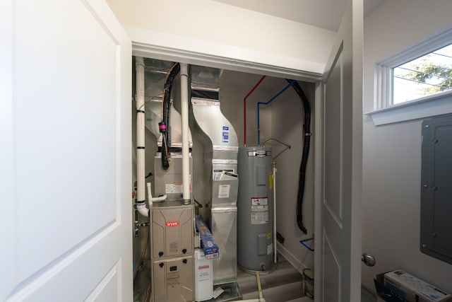 utility room featuring water heater, heating unit, and electric panel