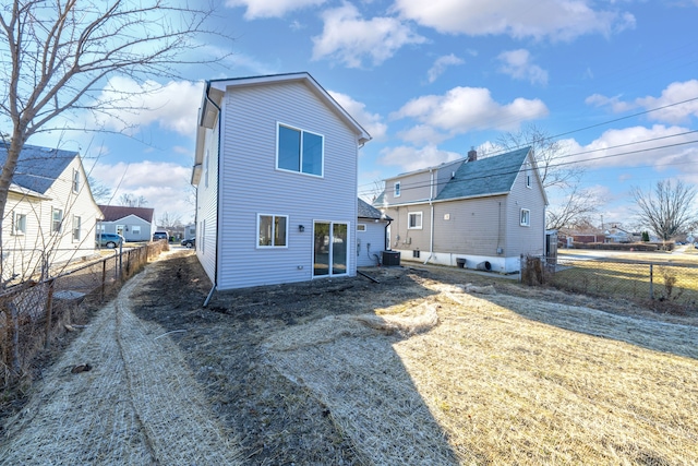 back of property featuring central AC and fence