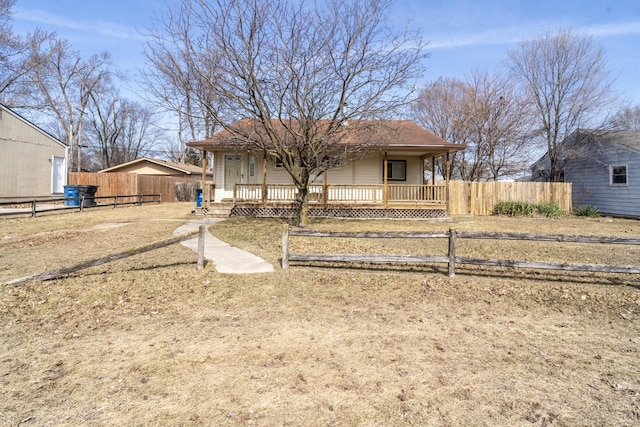 view of front facade featuring covered porch and fence