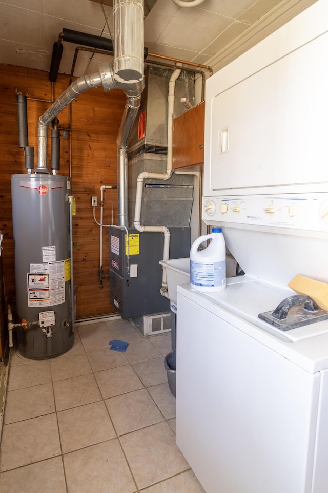 utilities with water heater and stacked washing maching and dryer