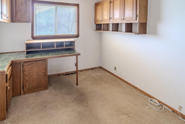 unfurnished office featuring light colored carpet and baseboards