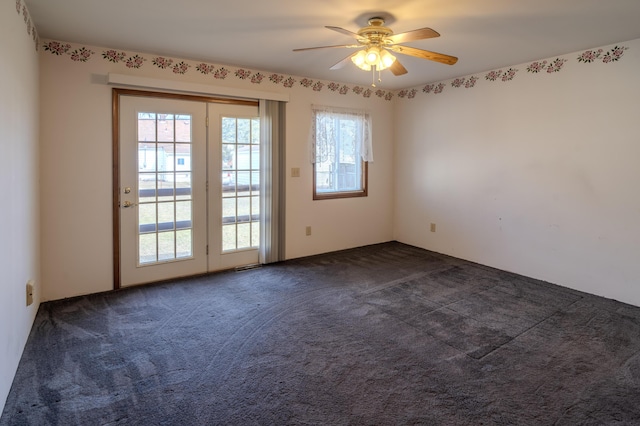 spare room with dark carpet and a ceiling fan