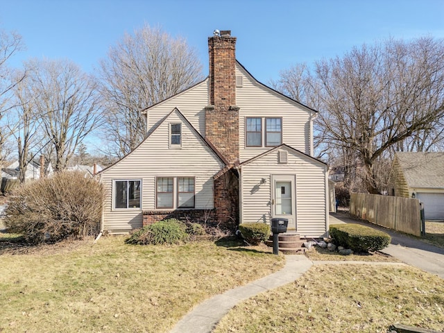 view of front of house featuring a chimney, a front lawn, and fence