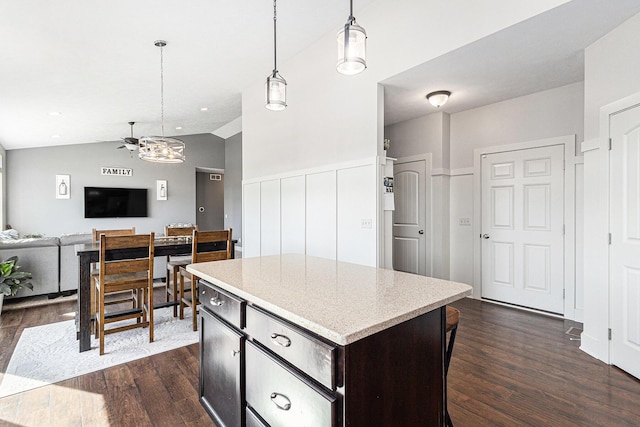 kitchen with lofted ceiling, a kitchen island, dark wood-style flooring, and pendant lighting