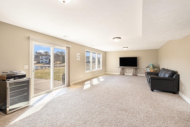 living area with baseboards, carpet floors, and a textured ceiling