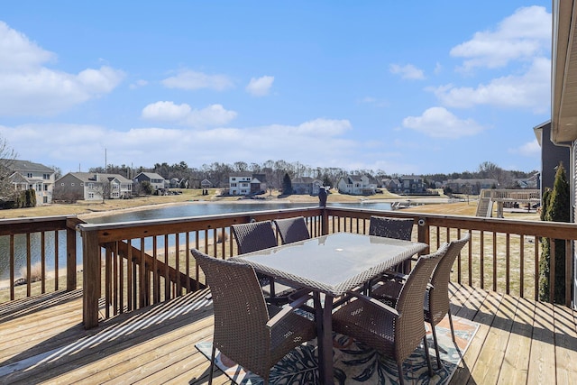 wooden terrace with outdoor dining space, a residential view, and a water view