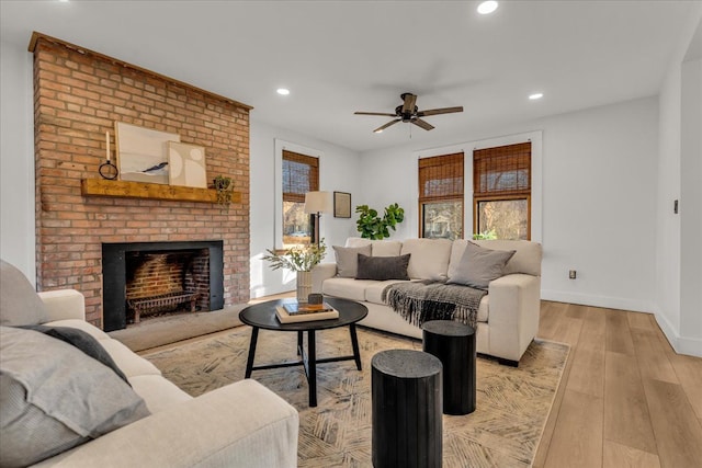 living room featuring recessed lighting, light wood-style flooring, a fireplace, and baseboards