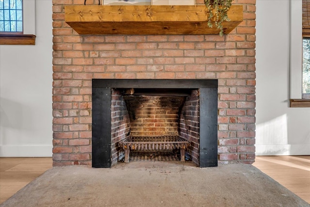 room details featuring baseboards, wood finished floors, and a fireplace