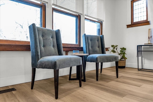 sitting room with visible vents, baseboards, and light wood-style floors