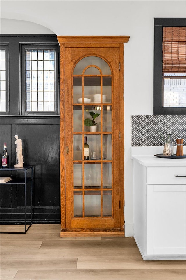 details featuring wood finished floors and backsplash