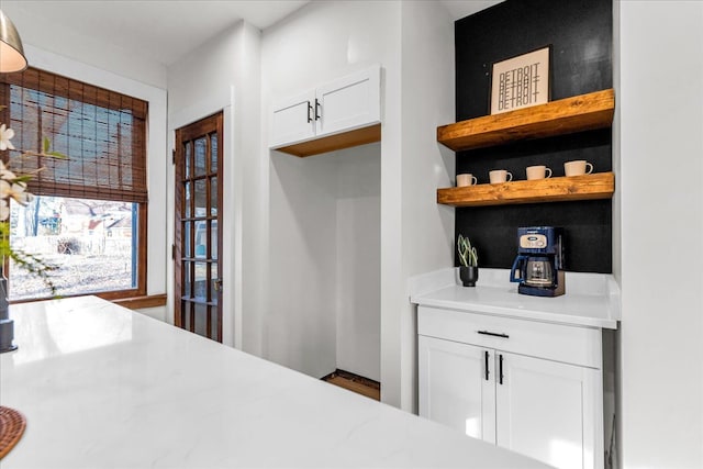 interior space featuring open shelves, light countertops, and white cabinetry