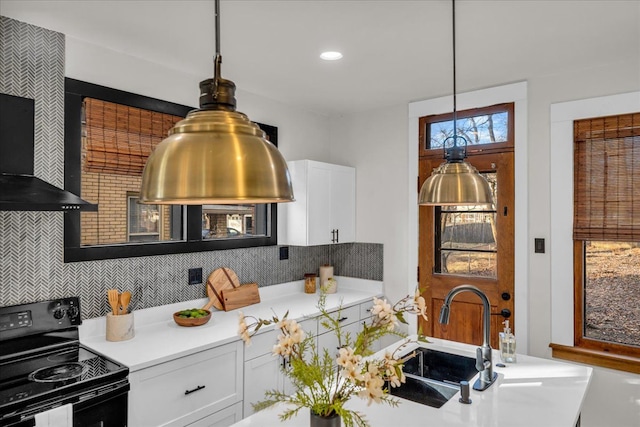 kitchen with a sink, black / electric stove, tasteful backsplash, and white cabinetry