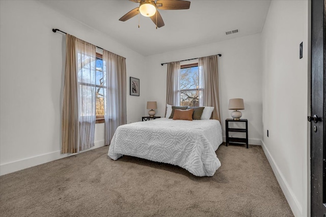 carpeted bedroom featuring visible vents, baseboards, and a ceiling fan