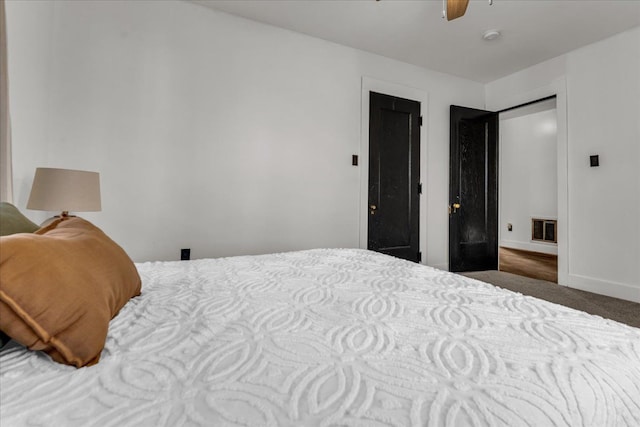 carpeted bedroom with visible vents, ceiling fan, and baseboards