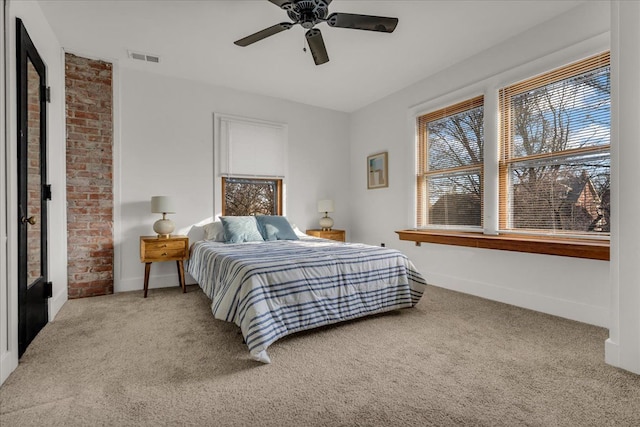 carpeted bedroom with visible vents, baseboards, and ceiling fan