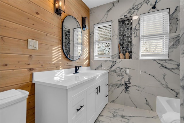 full bath with vanity, toilet, plenty of natural light, and marble finish floor