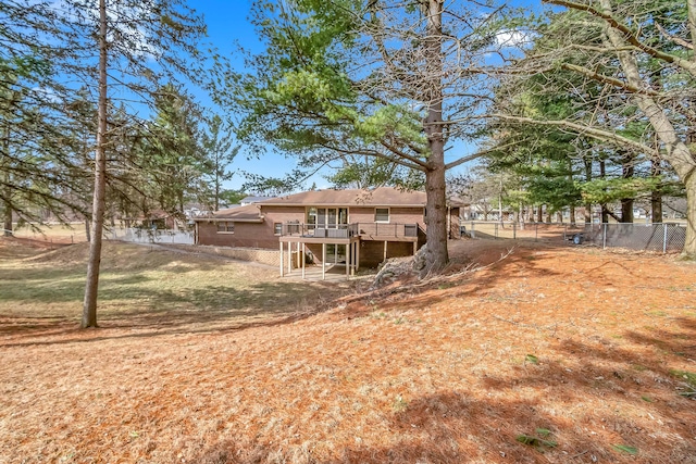 rear view of property featuring a deck, stairs, and fence