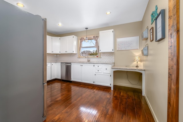 kitchen featuring light stone countertops, dark wood-style flooring, stainless steel appliances, white cabinets, and backsplash