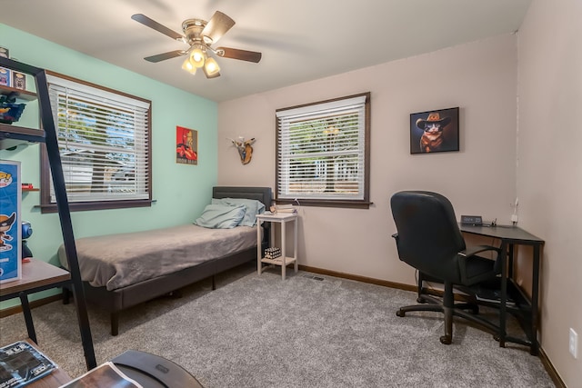 carpeted bedroom with ceiling fan and baseboards