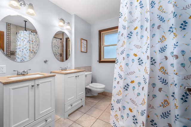 full bathroom featuring toilet, tile patterned floors, two vanities, and a sink