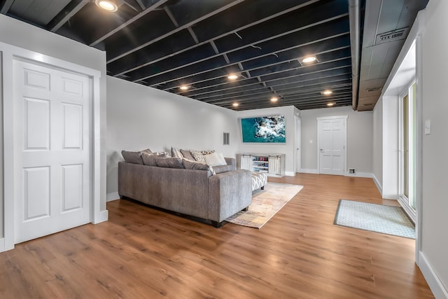 living area featuring light wood finished floors, visible vents, and baseboards