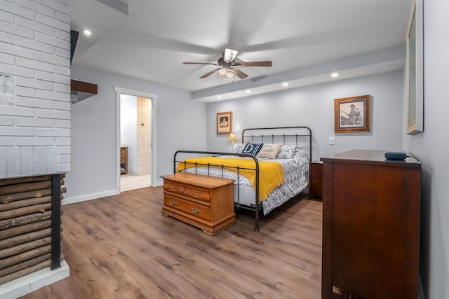 bedroom with recessed lighting, ensuite bathroom, baseboards, and wood finished floors