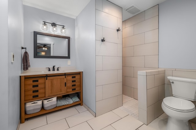 bathroom with tile patterned floors, visible vents, toilet, a walk in shower, and vanity