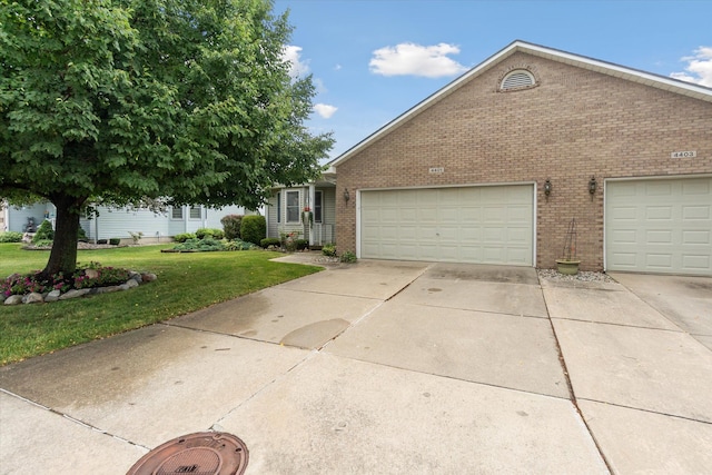 view of front facade featuring brick siding, driveway, an attached garage, and a front lawn