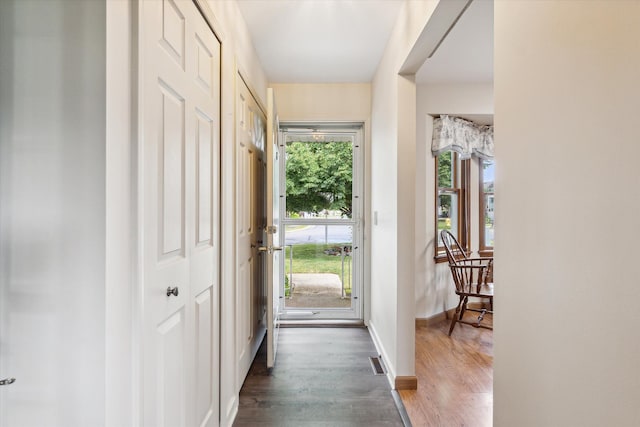 foyer entrance with wood finished floors, visible vents, and baseboards