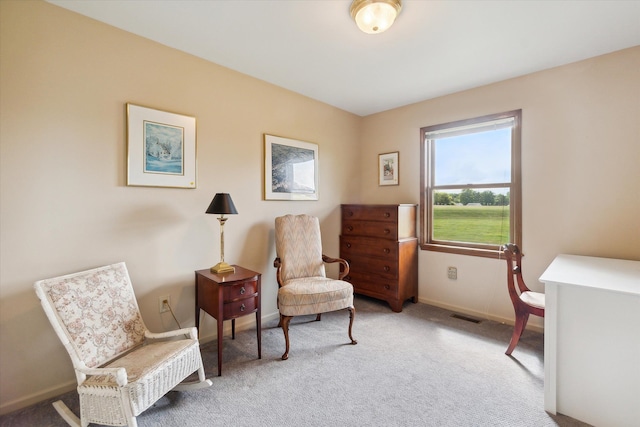 living area featuring carpet flooring, visible vents, and baseboards