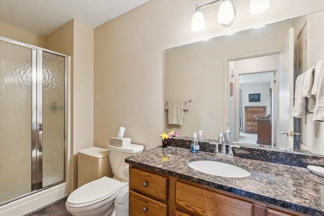 bathroom with vanity, toilet, and a shower stall