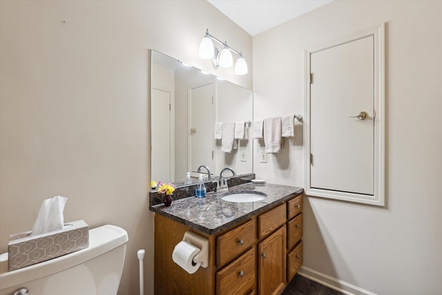 half bath with vanity, toilet, and baseboards