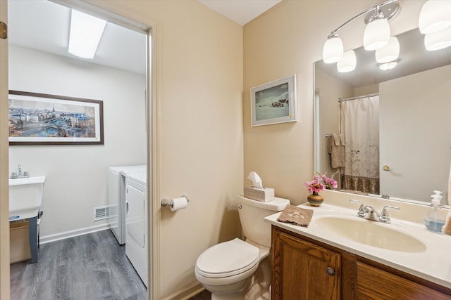 full bath with vanity, a shower with shower curtain, wood finished floors, separate washer and dryer, and toilet