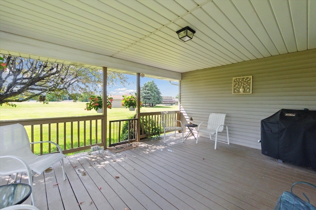 deck featuring grilling area and a lawn