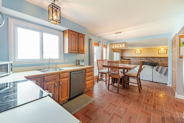 kitchen with a sink, light countertops, brown cabinets, and stainless steel appliances