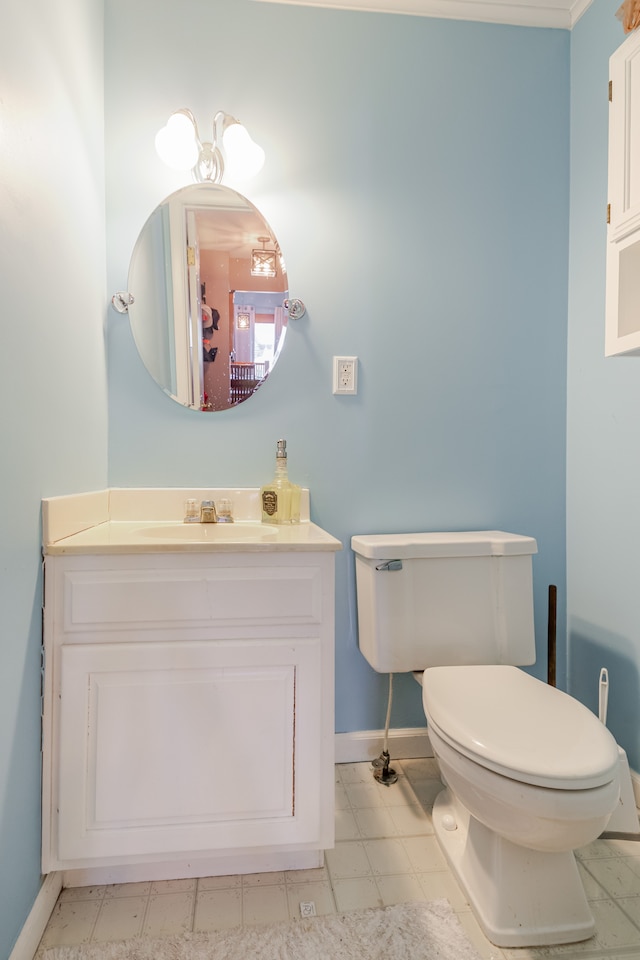 bathroom with baseboards, toilet, and vanity