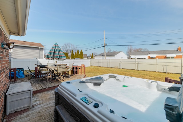 view of yard with a fenced backyard, outdoor dining space, a hot tub, and a deck