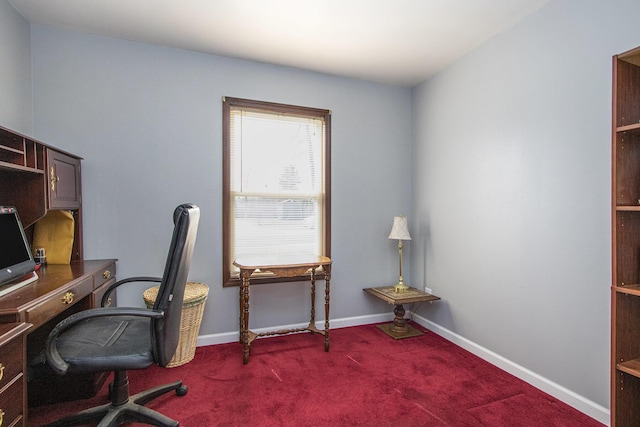 home office with baseboards and dark carpet